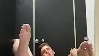 Guy showing feet and cum in public stall
