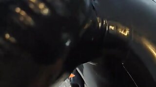 The latex puppy is enjoying a big meat stick.