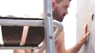 Cute guy gives someone a blowjob through a gloryjhole in the shower